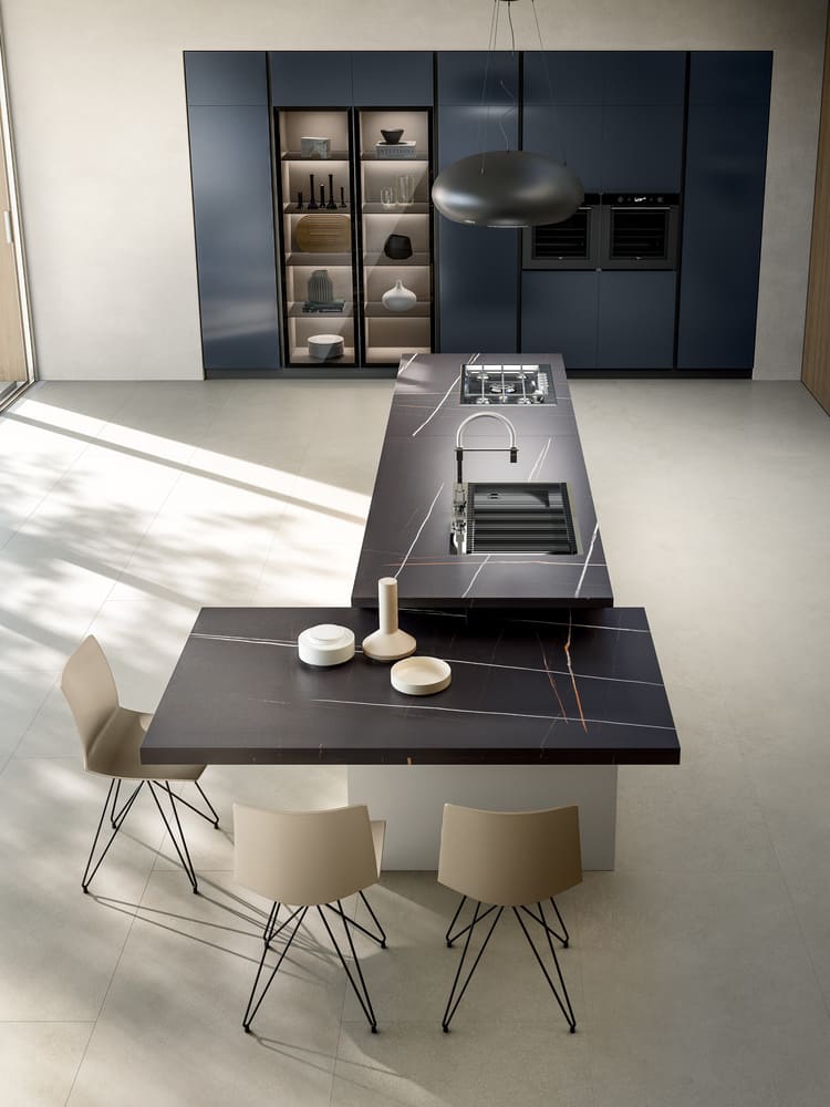 a kitchen with a black countertop and chairs