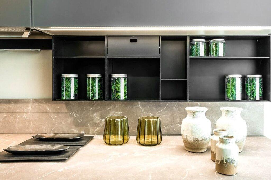 a kitchen counter with a shelf and jars