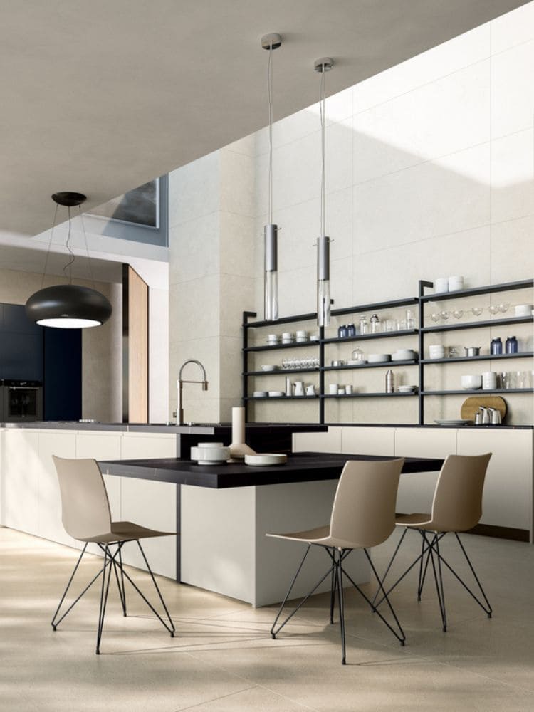 a kitchen with a black countertop and chairs