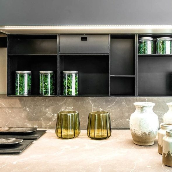 a kitchen counter with a shelf and jars